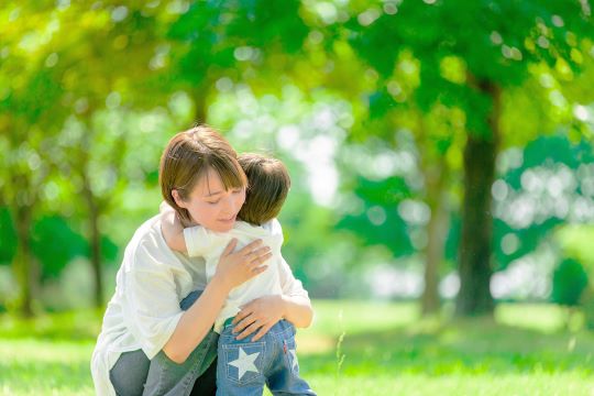 A mother hugging her child in the green