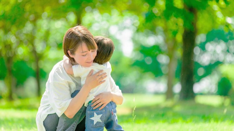 A mother hugging her child in the green